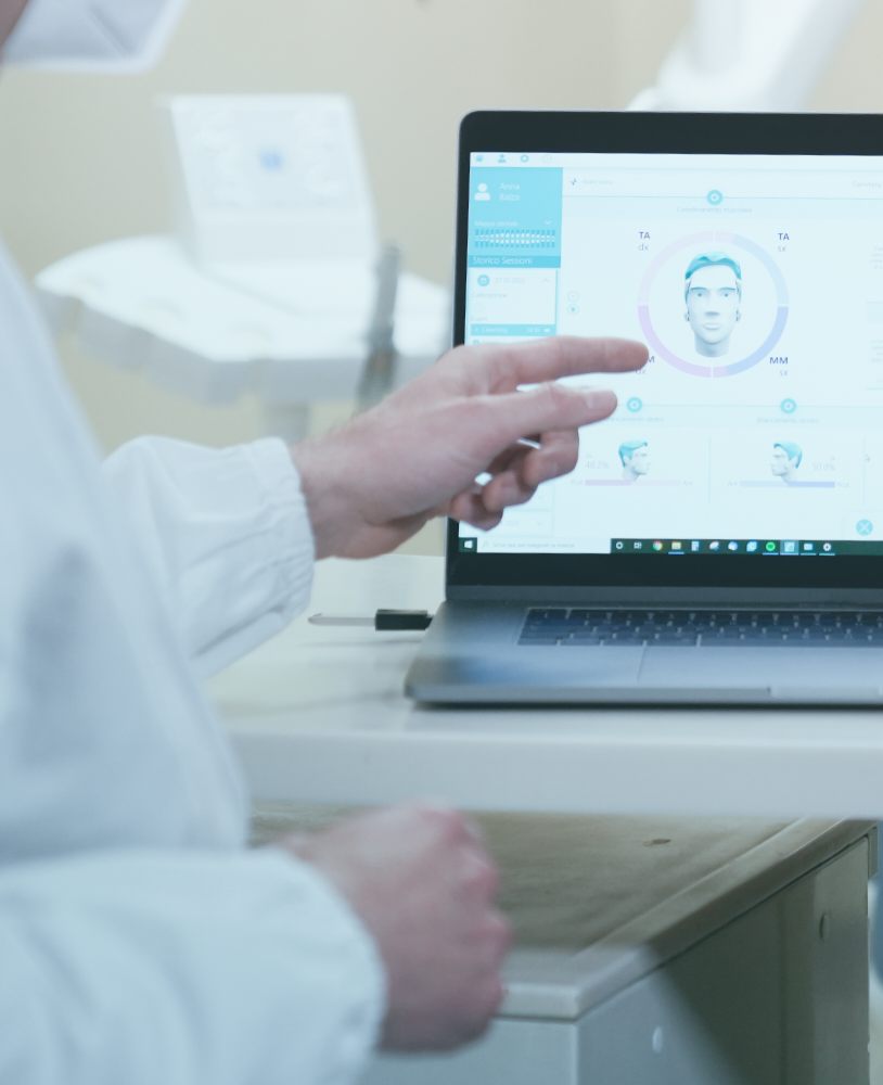 Zahnarzt analysiert Myowise EMG-Okklusionsdaten in der Software am Laptop