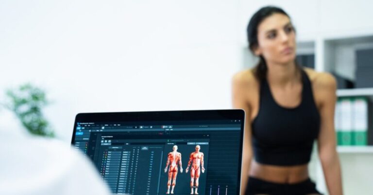 Therapeut wertet EMG-Verlauf am Tablet mit Patientin aus